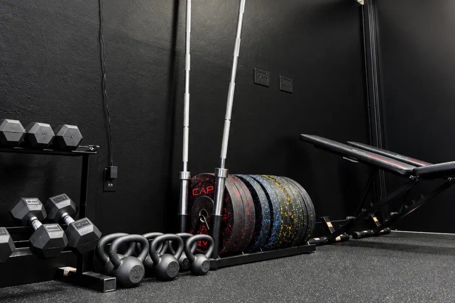 Weight training area with barbells, dumbbells and plates at BodyRhythm